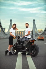 Foto op Plexiglas Love and romantic concept. Beautiful couple on motorcycle stands opposite each other in the middle of the road on the bridge, on double solid © Georgii
