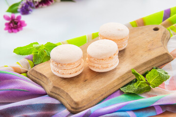 Fototapeta na wymiar Macarons and mint for dessert - healthy organic summer dessert. Creative atmospheric decoration.