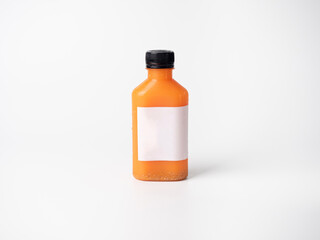 orange pastel color drink in plastic bottle container with empty logo label. mixed many vegetables and fruits smoothie juice on studio background.