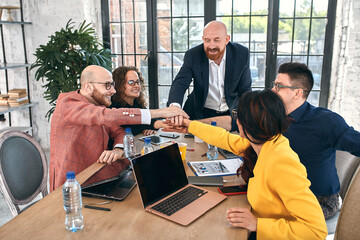 Group of joyful smiling happy people celebrate win with arms up. Mediation offer high five...
