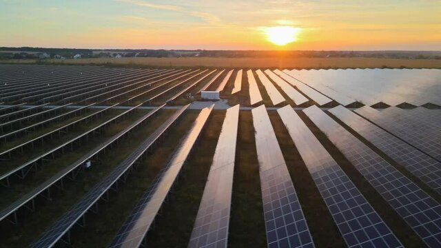 Aerial drone view into large solar panels at a solar farm at bright sunset. Solar cell power plants. HDR footage video 4k.