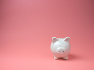 white piggy Bank on  pink background with copyspace for design.