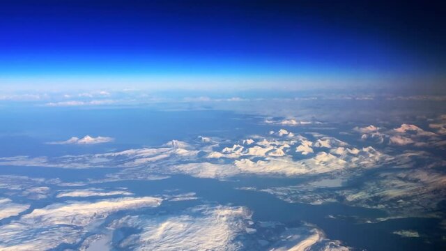 Aerial view over the frozen snowy mountains of Norther Norway during a beautiful winter day,