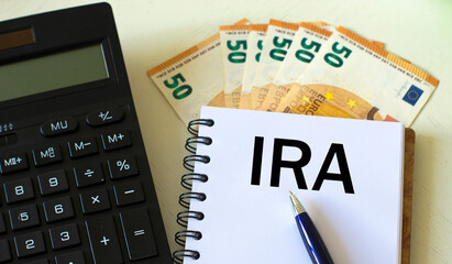 IRA word in a notebook against the background of calculitar and banknotes