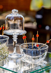 Crystal tall stand for cake. Blueberries stand in a glass plate. Blurred background. Close up.