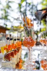 Tasty appetizers served in glass jars on table. Cocktail snack. Catering concept. Closeup.