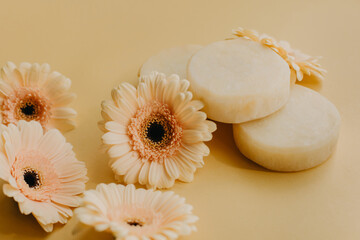 Fototapeta na wymiar Cosmetic soap with flowers on yellow background.