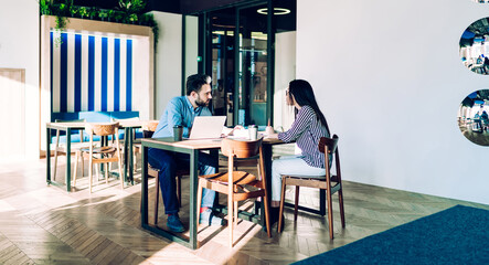 Serious partners talking at workplace