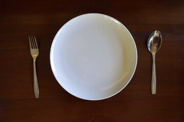tableware on the table, consisting of a white plate fork and spoon