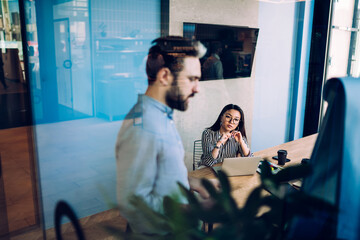 Asian woman listening to coworker in office