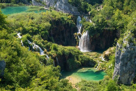 Plitvice lakes in Croatia. National Park in summer. Waterfalls and lakes among the forest. Footpath for hiking. Croatian travel image.