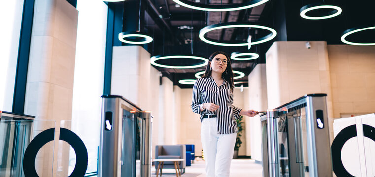 Young woman passing through automatic entrance gate in office