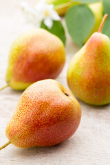 Fresh pears with leaves in a on wooden background.