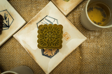 Flat lay mid autumn festival colorful food and drink on burlap background.
