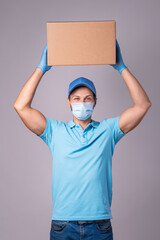 Young delivery man is wearing prevention mask and gloves with a cardboard boxes