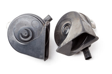 Pair of electric black plastic horns in retro style - car horn on white isolated background in photo studio. Spare part for sale or repair in a workshop, or tuning a buzzer sound in car service.