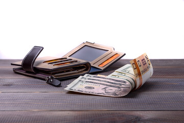 Men's leather wallet with bank cards and money. Wallet and money on a wooden table.