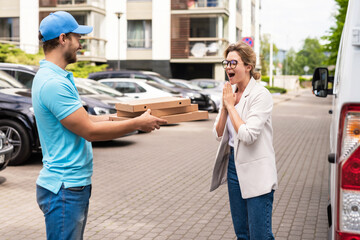 Delivery man wearing blue uniform delivers pizza to a woman client