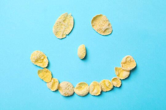 Smiley face made of muesli on blue background - Powered by Adobe