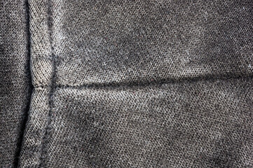 clothing items stonewashed cotton fabric texture with seams, clasps, buttons and rivets, macro