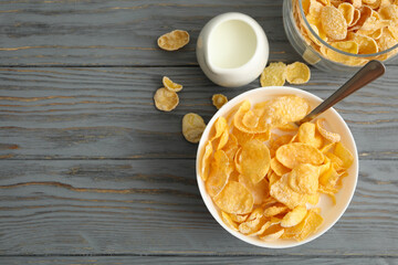 Milk, bowl and jar of muesli on wooden background