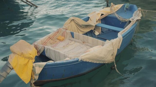 A small fishing boat, gently shaken by sea waves. Smooth colors, relaxing shot.
