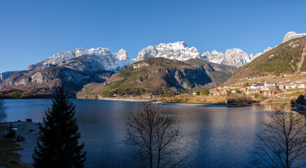 Fototapeta na wymiar View of the city of Molveno and the snow-capped peaks of the Dolomites.