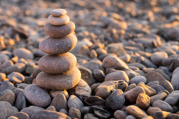 Fototapeta na wymiar Zen pyramid of stones at sunset.