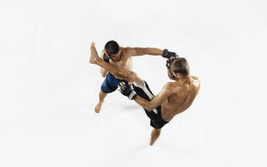 Two professional MMA fighters boxing isolated on white studio background. Top view of couple of muscular athletes. Sport, healthy lifestyle, competition, dynamic and motion, action concept. Copyspace.