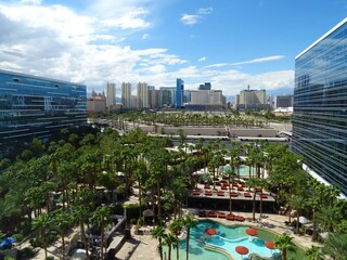 Las Vegas skyline view from Hardrock hotel with blue sky and clouds, pool, trees September 2018