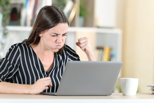 Angry woman checking laptop at home