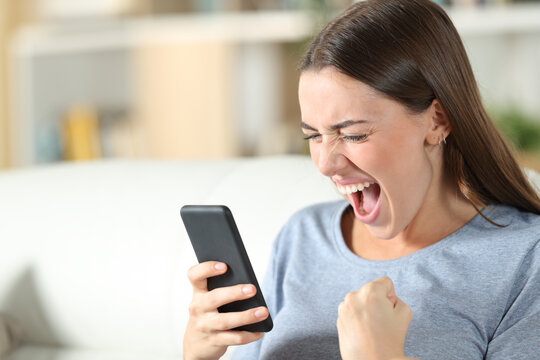 Excited teen checking good news on mobile phone