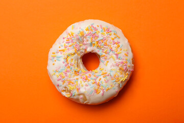One tasty donut on orange background, close up