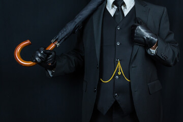 Successful British Businessman in Dark Suit and Leather Gloves Holding Umbrella Over His Shoulder. Classic English Gentleman. Wealth and Power. Sartorial Splendor.