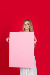 Happy woman holds empty advertising banner. Woman shows empty board. Ready for your text. Beauty woman with blank sign board. Smiling girl holding blank poster with space for text.