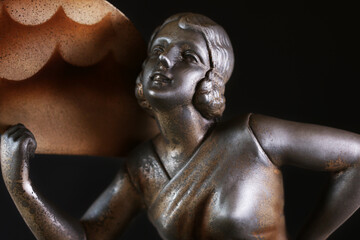 Ritratto di una giovane, elegante donna con ventaglio. Primo piano di scultura in metallo, tipico...