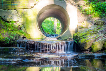 A flowing stream trickles down through a circular hole.