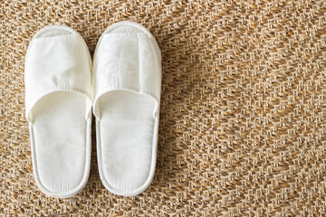 White slippers on weave mat with copy space.