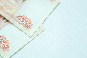 Russian 5000 rubles currency money on white background with copy space asa symbol of business and prospeity. Focus on number 5000 on red banknote