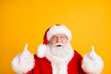 Close up photo of astonished grey beard santa claus point index finger up copyspace present x-mas magic miracle newyear ads wear cap headwear isolated over bright shine color background