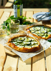 Italian cheese and zuccini galette served outdoors on a garden table with white wine. Outdoor meals concept