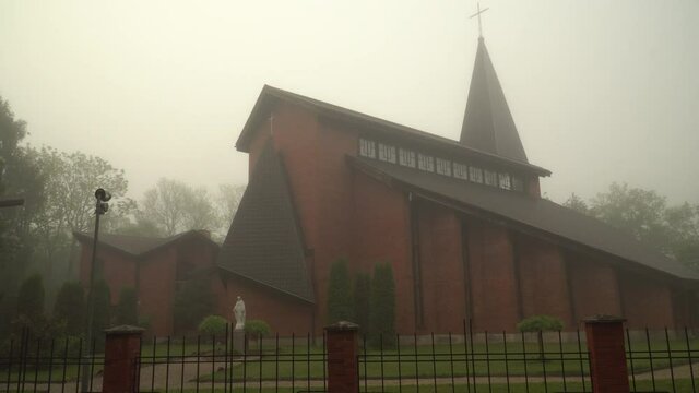 Dobele Holiest Trinity Roman catholic church. The majestic brick building of the catholic church built in the style of modern architecture, the scenic view on a foggy morning.