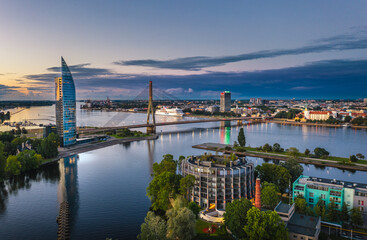 Riga city panorama with colorful sunset in the sky. Modern architecture meets old town. Picturesque view over riverside. 
