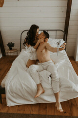 Couple in love making photos in bed