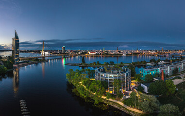 Riga city panorama with colorful sunset in the sky. Modern architecture meets old town. Picturesque view over riverside. 