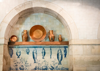 Kitchen Wall With Copper Cookware And Tile (Azulejos) Scene Of Hanging Fish, Lisbon, Portugal 
