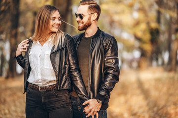 A young couple in love walking in the autumn park on a sunny day