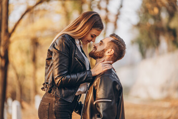 Fototapeta premium Young couple kissing on the background of the autumn park