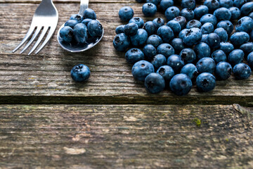 Delicious, organic, home growth blueberries on aged wooden background, space for text.