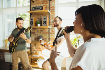 Inspiration. Musician band jamming together in art workplace with instruments. Caucasian men and women, musicians, playing and singing together. Concept of music, hobby, emotions, art occupation.